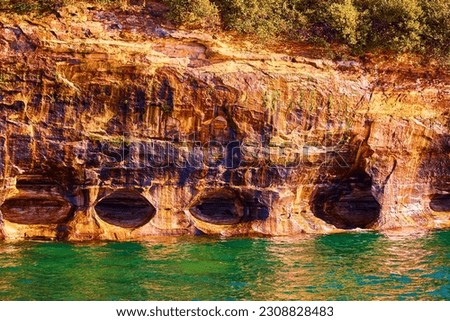 Turquoise water and ominous caves and hollow cliff side cavers Pictured Rocks