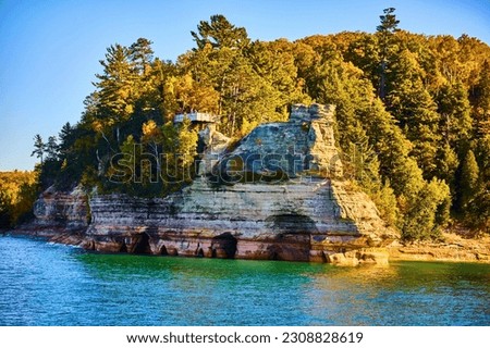 Castle rock Pictured Rocks with caverns in water of Lake Superior Michigan with lush green forest