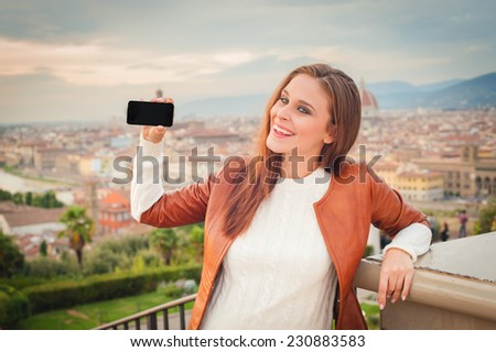 Beautiful young woman making a picture with background of Florence