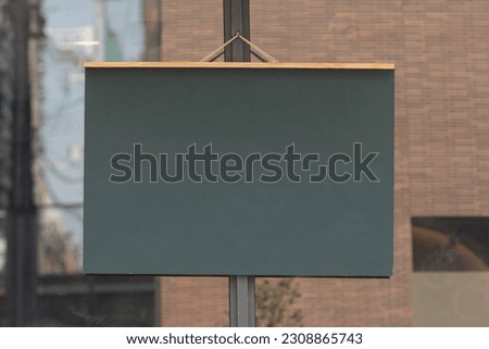 Clean black chalkboard hanging on cafe or restaurant hang on door at entrance.