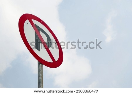 A "No Parking" traffic sign against a backdrop of a blue sky.