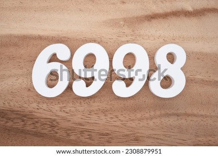 White number 6998 on a brown and light brown wooden background.