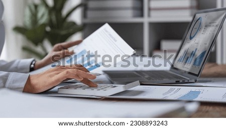 Business woman using calculator for do math finance on wooden desk in office and business working background, tax, accounting, statistics and analytic research concept