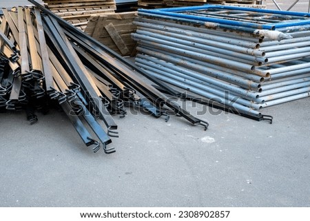 Scaffolding dismantled and stacked on the pavement Royalty-Free Stock Photo #2308902857