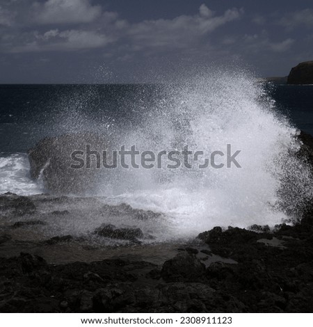 Gran Canaria, north west coast around natural swimming pools Salinas de Agaete, 
waves breaking against old eroded dark lava platform Royalty-Free Stock Photo #2308911123