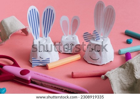 Creative simple DIY children's craft - family of rabbit from egg carton package. Finished toys and tools. Eco friendly reuse recycle idea, decoration for Easter, Father's, Mother's, family day gift. Royalty-Free Stock Photo #2308919335