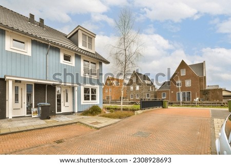 a street with houses in the background and a car parked on the side of the road next to the house