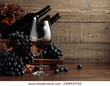 Red wine and blue grapes. Wine and grapes in a vintage setting on an old wooden table. Royalty-Free Stock Photo #2308929763