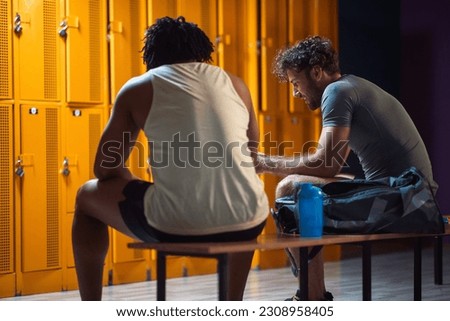 Two men in the locker room having a conversation after workout, enjoying each others company. Wellness, sports, lifestyle concept. Royalty-Free Stock Photo #2308958405