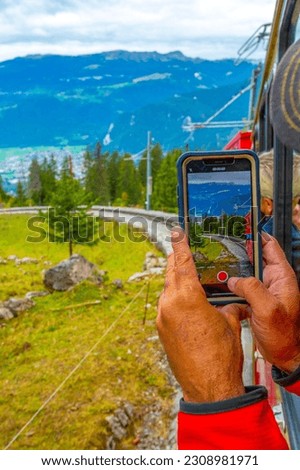 People taking photos from Schynige Platte trail in Bernese Oberland, Canton of Bern, Switzerland. Popular mountain in the Swiss Alps called Schynige Platte in Switzerland, aerial view.
