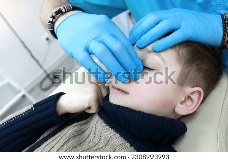 Osteopath treats respiratory system of kid on couch in clinic Royalty-Free Stock Photo #2308993993