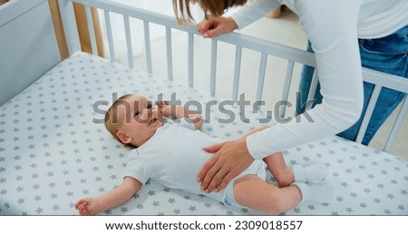 Top view. Mom playing to adorable newborn baby on bed smiling and happiness at home. Happy baby boy smile and laugh loudly. Royalty-Free Stock Photo #2309018557