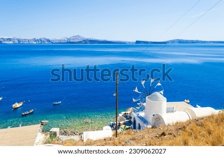 Windmill at Thirasia or Therasia island coast,Santorini siland seen across the Caldera.After the eruption of the volcano Santorini two major islands were left-Santorini and Therasia opposite it. Royalty-Free Stock Photo #2309062027
