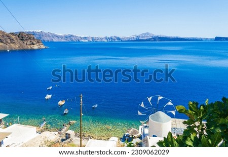 Windmill at Thirasia or Therasia island coast,Santorini siland seen across the Caldera.After the eruption of the volcano Santorini two major islands were left-Santorini and Therasia opposite it. Royalty-Free Stock Photo #2309062029