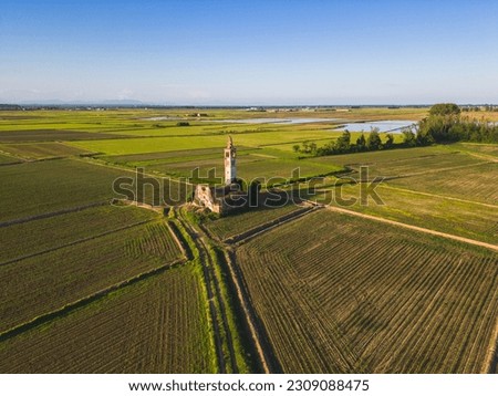 Aerial view of abandoned church in the middle of the wheat fields with rise fields in background. Novara, Piedmont Royalty-Free Stock Photo #2309088475