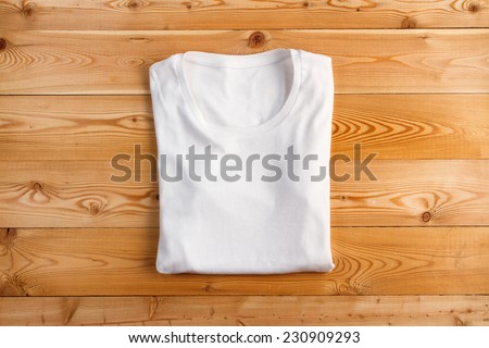 White t-shirt on a wooden background Royalty-Free Stock Photo #230909293