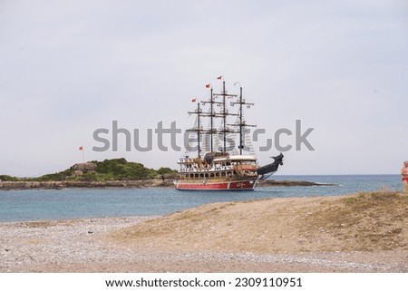 Pirate Ship off Shore in Tropical Water with beach in foreground