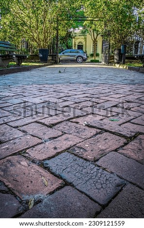 A very low angle photo on a cobblestone street facing a home in evening light.