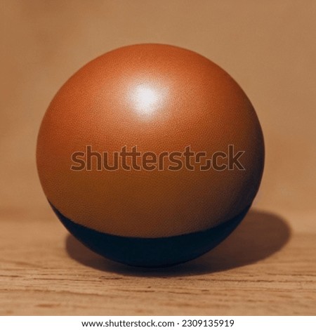 In this 8K quality picture, we find a prominent orange ball resting on the ground. Its vibrant colors shimmer and reflect light beautifully, adding a touch of natural beauty to the scene. 