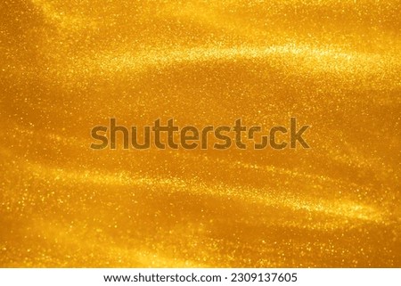 Glittering flows of gold particles in fluid. Various stains and overflows of golden dust particles in liquid with yellow tints. Fantastically beautiful abstract background. Royalty-Free Stock Photo #2309137605