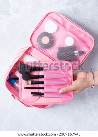 A beautiful pink cosmetic bag with the necessary products for the care of women's skin. Cosmetics, shampoo, creams, makeup brushes in a cosmetic bag against the backdrop of a beautiful women's room. Royalty-Free Stock Photo #2309167945