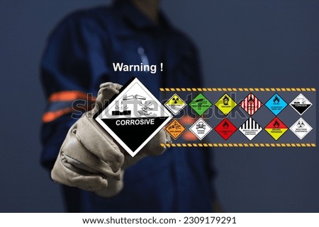 Staff with glove holding the corrosive sign one of dangerous substance or goods in the worning list chemical industrial process. Acid effect health or industrial waste management under ISO 14001.
