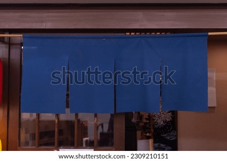 The curtain-like fabric that hangs in front of traditional Japanese restaurants and shops not only serves as a signboard, but holds a larger meaning, Royalty-Free Stock Photo #2309210151