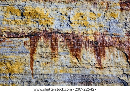 Background asset streaks of painted minerals on Pictured Rocks with yellow and rust