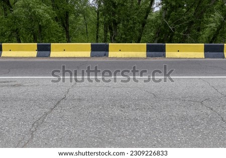 black and yellow concrete fenders along the road