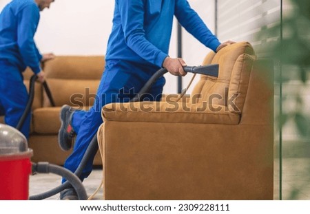 Machine upholstery cleaning.Cleaning furniture.Two workers cleaning upholstery Royalty-Free Stock Photo #2309228111