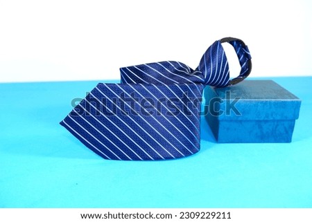 lining pattern zipper necktie folded isolated over blue and white background close up shot, striped pattern men's fashionable neck tie display for business concept  Royalty-Free Stock Photo #2309229211