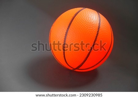 Close up photo of a small size basketball for children, orange color isolated on gray background.