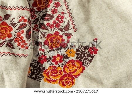 Ukrainian clothes embroidered shirt. Red orange and black threads background. Vyshyvanka is a symbol of Ukraine. Embroidery cross stitching. National Ukrainian stitch. Traditional clothing symbol. Royalty-Free Stock Photo #2309275619
