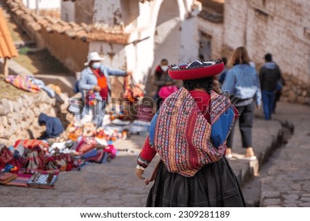 Rear view of peruvian indigenous woman dressed in traditional colorful clothes Royalty-Free Stock Photo #2309281189