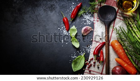 Wooden spoon and ingredients on dark background. Vegetarian food, health or cooking concept. Royalty-Free Stock Photo #230929126