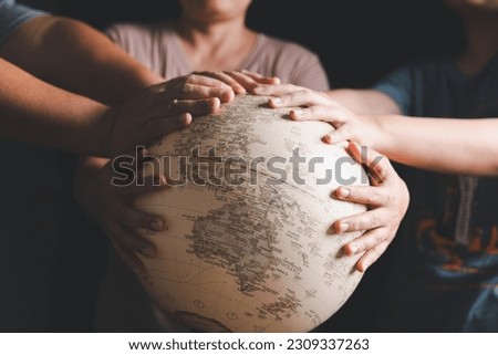 Christian group praying for globe and people around the world on wooden table with bible. Christian small group praying together around a wooden table with bible page in homeroom. Royalty-Free Stock Photo #2309337263