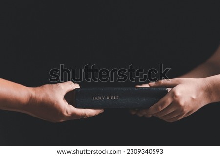Woman hands giving bible. Mission to spread the gospel and religion of Christianity around the world. hands holding bible on wooden table. Royalty-Free Stock Photo #2309340593