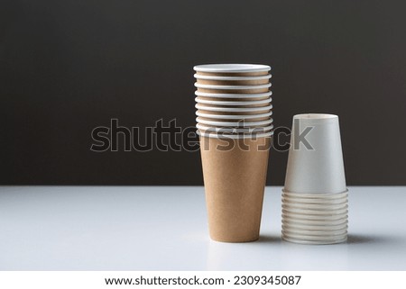 Disposable cardboard biodegradable cups on a white table, gray background.