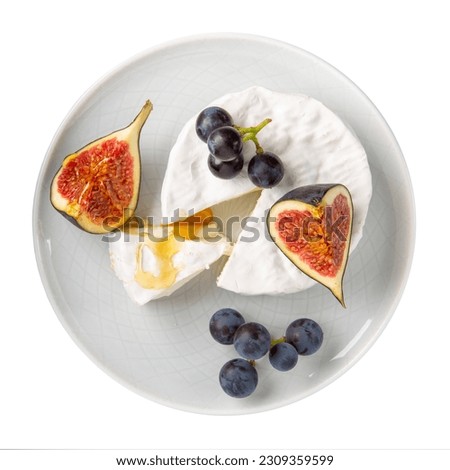 Cheese plate isolated on white background. Brie cheese served with  fruits and honey on gray plate. Top view. Royalty-Free Stock Photo #2309359599