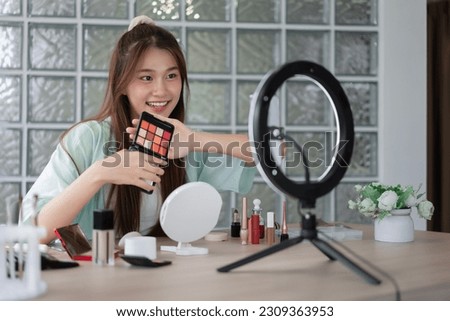 Beauty influencer concept, Young woman show eyeshadow to present product and record video for Vlog.