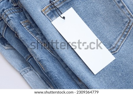 Lots of jeans pants in a stack. Denim background. The concept of buying, selling, shopping and trendy modern clothes.