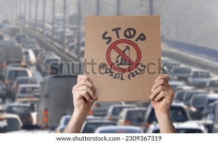 Stop fossil fuels poster over traffic jam background. CO2 emissions, battle for climate change