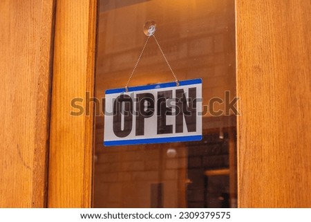 Open text sign on a glass entrance door, close up 