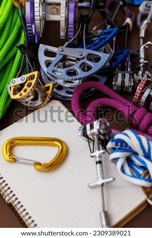 Travel planning. Notepad, rope and carabiner. Climbing equipment. notebook and equipment for insurance and travel. 