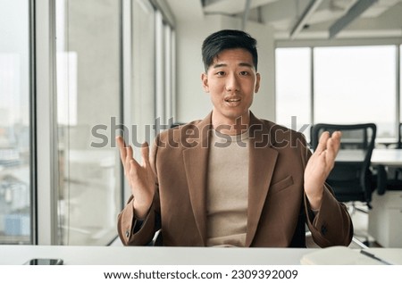 Young Asian business man manager or teacher talking to camera having remote video conference call meeting, virtual hybrid interview, giving online class webinar training, consulting client in office. Royalty-Free Stock Photo #2309392009