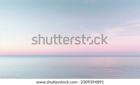 Clear blue sky sunset with glowing pink and purple horizon on calm ocean seascape background. Picturesque