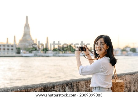 Portrait beautiful asian woman smiling while travel at Wat Arun sunset view point, Bangkok, Thailand.