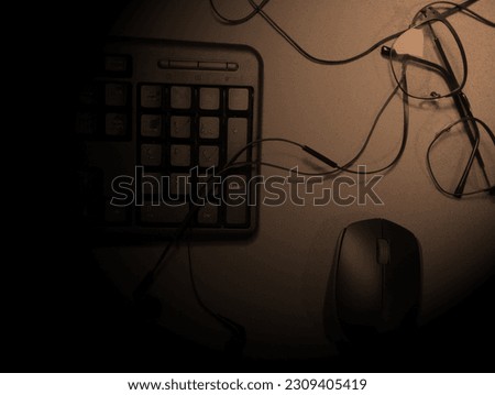 Work from home. office desk with keyboard, headset, glasses and pen on the table in classic black and white background