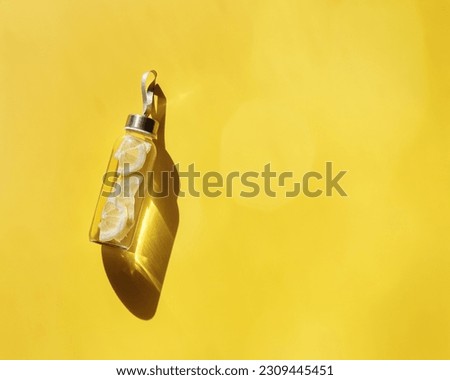 Cleansing and refreshing Lemon water drink detox, shadow at sunlight on yellow background with sun glare. Wellness, alkaline diet, eating healthy concept. Stylish glass reusable water bottle, top view Royalty-Free Stock Photo #2309445451