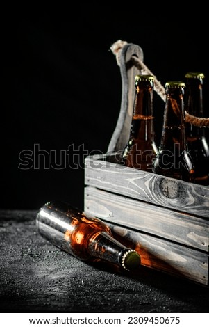 Bottles of beer in a box. On rustic background.